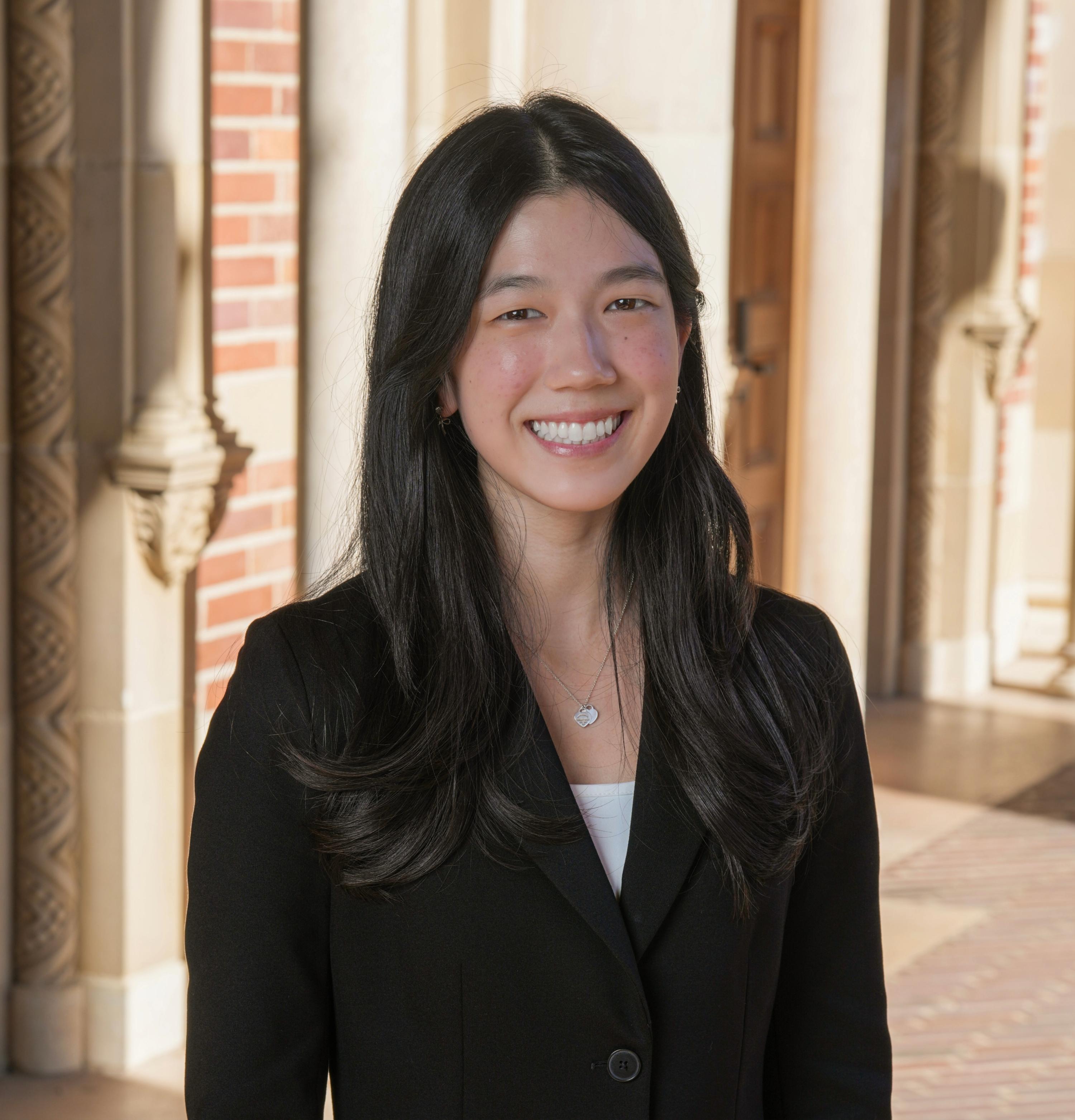 Headshot of Emily Kim from the shoulders up smiling in a suit.
