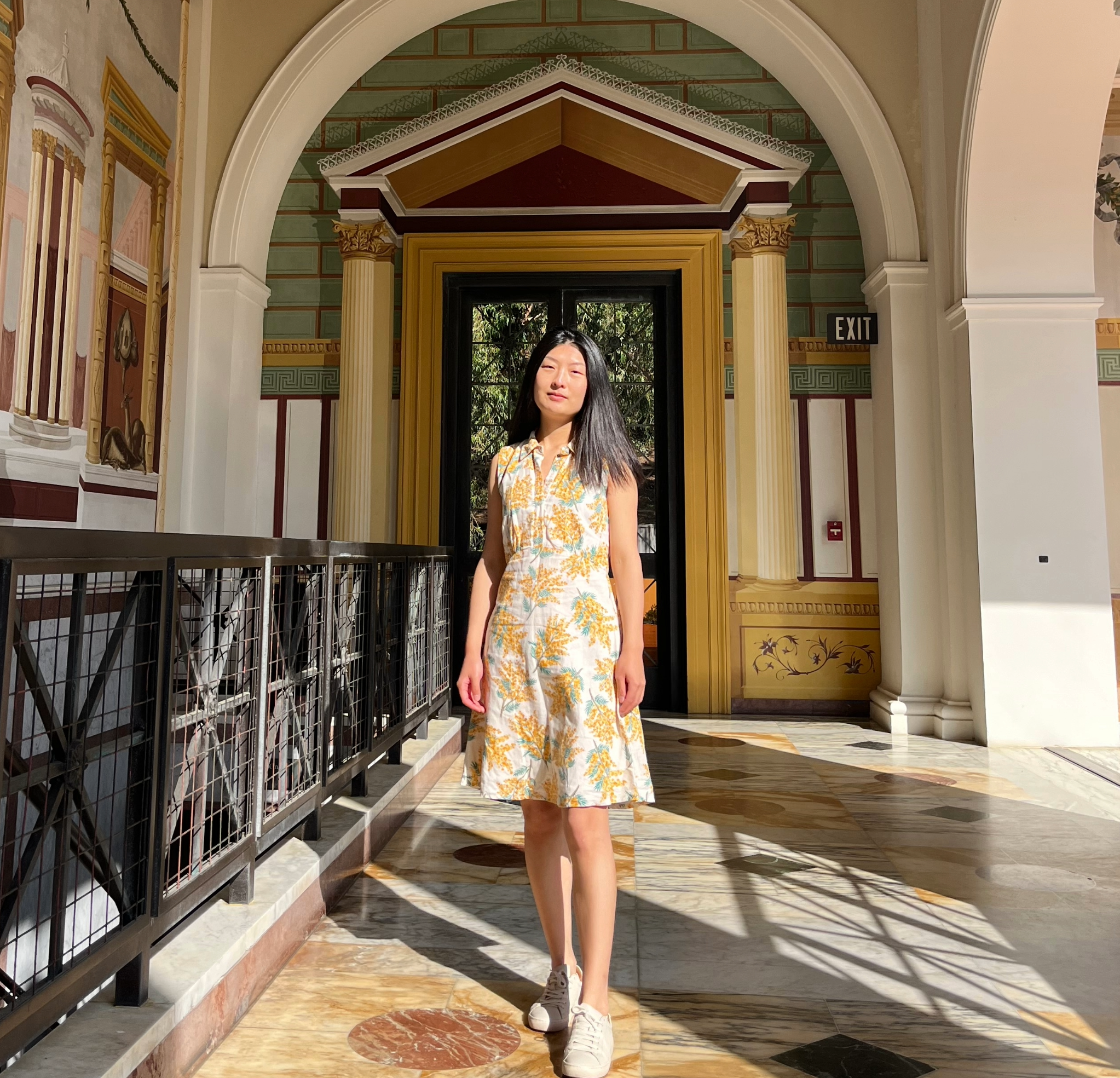 Picture of Yiping Wang smiling in a yellow floral dress.
