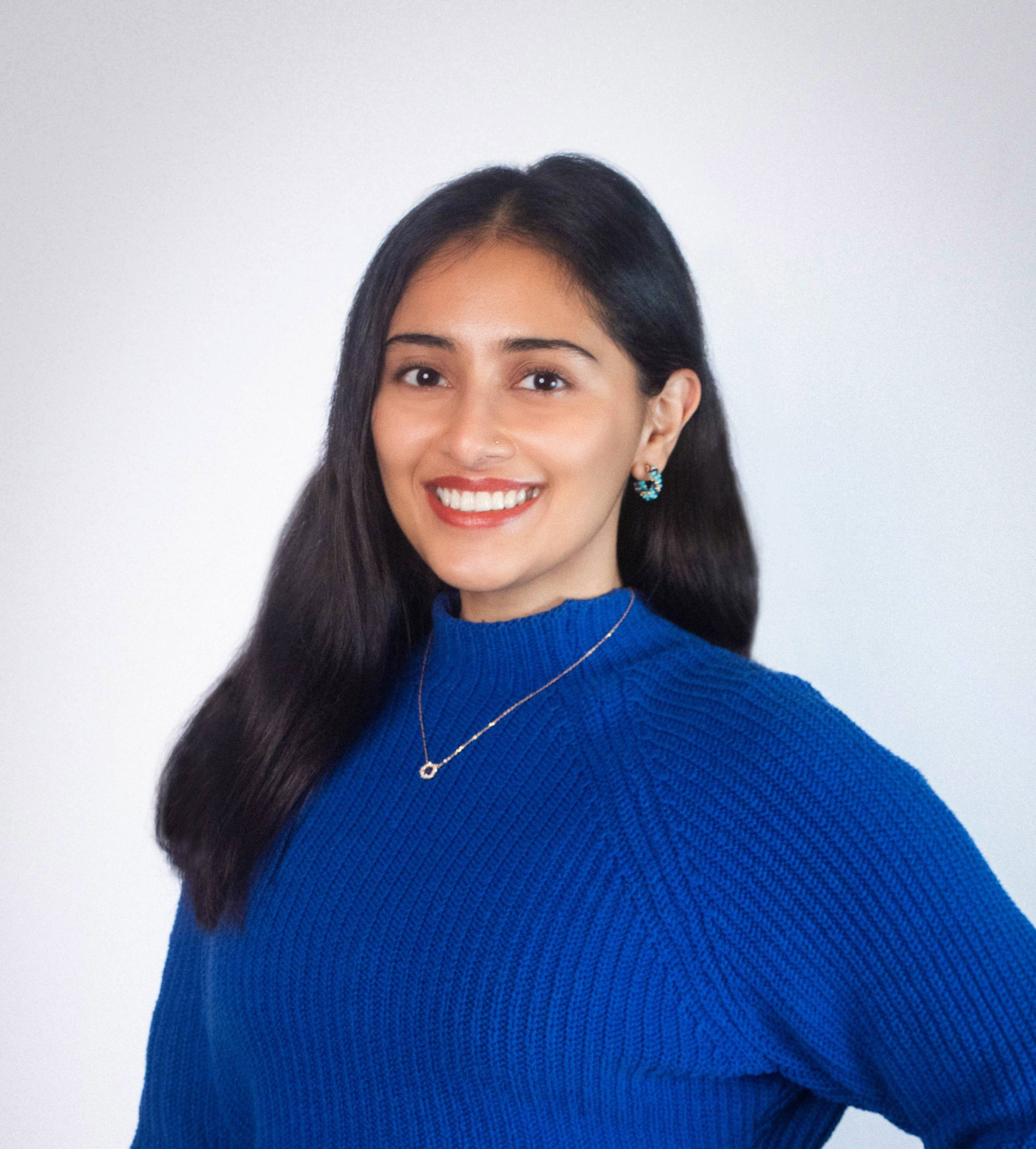 Picture of Sanjali Mitra smiling in a blue sweater.