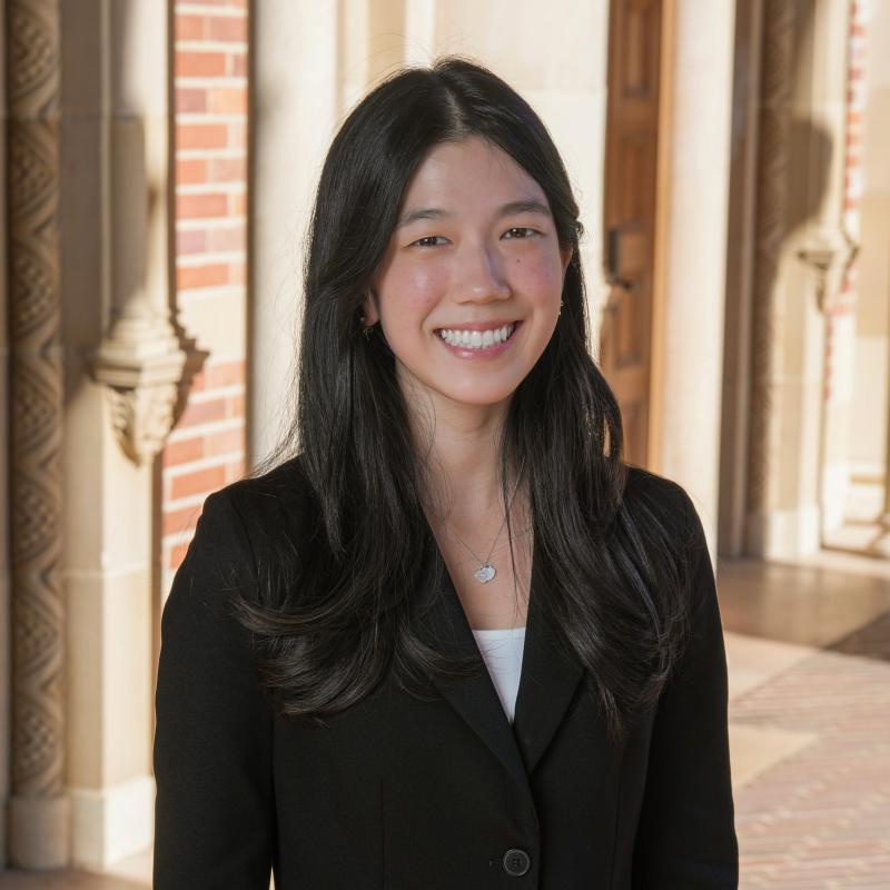 Headshot of Emily Kim from the shoulders up smiling in a suit.