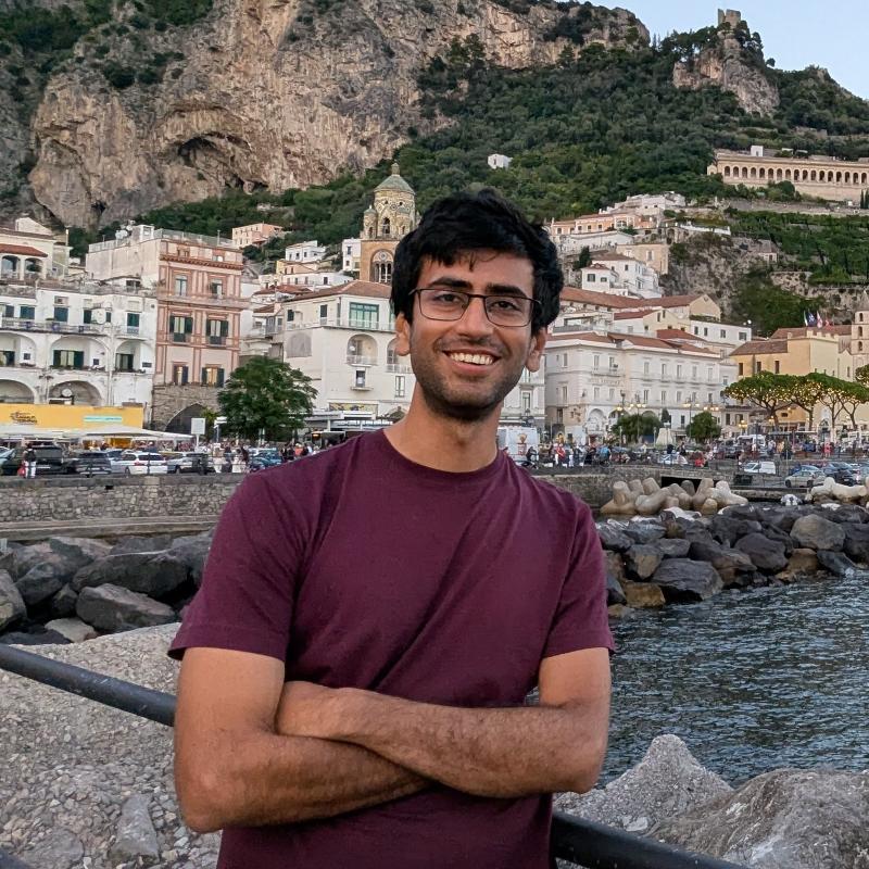 Headshot of Pratik Manwani smiling in a red shirt.